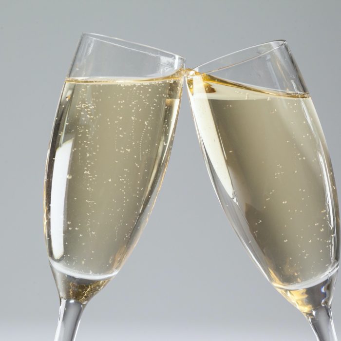 Close-up of two champagne flutes on white background